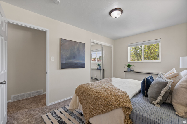 2370 Quail Run Circle East Sandy, UT 84093 - Photo 14 of 54 Bedroom featuring neutral wall paint, carpet flooring, a window with natural light, and a built-in closet with mirrored doors