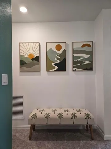 a bedroom with a bed and painting on the wall