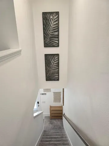 a hallway with stairs and a white wooden floor