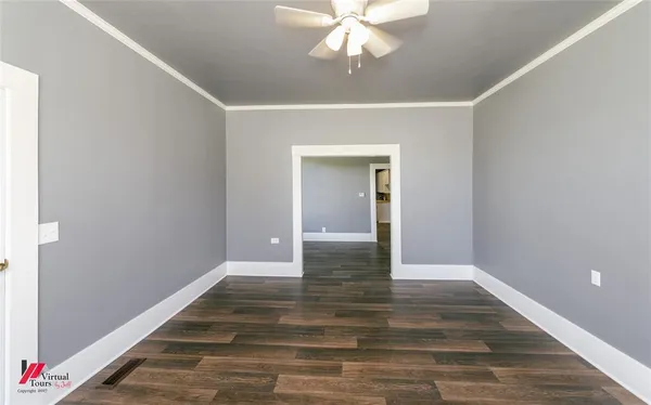 a view of an empty room with wooden floor