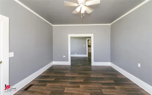 a view of an empty room with wooden floor