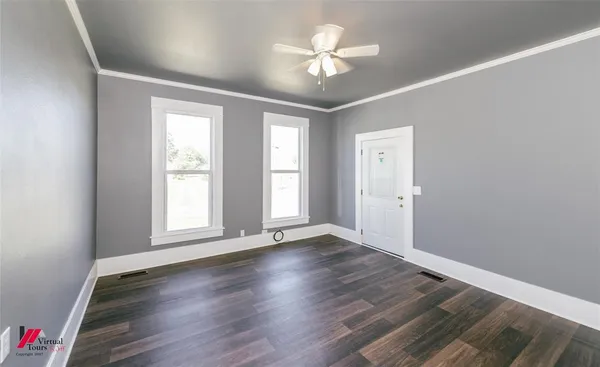 an empty room with wooden floor and window