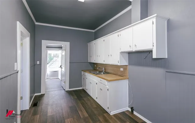 a kitchen with a sink and wooden floor