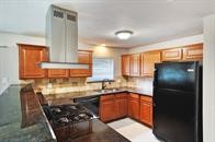 a kitchen with stainless steel appliances granite countertop a refrigerator and a sink