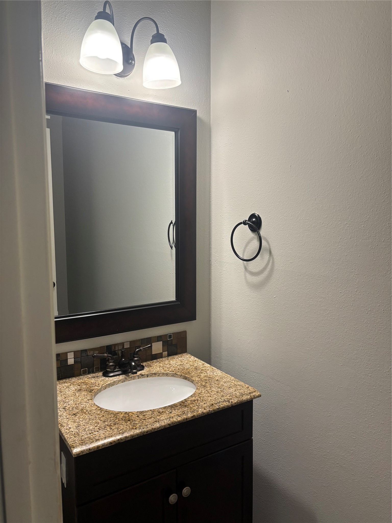 73 South Waxberry Road The Woodlands, TX 77381 - Photo 2 of 23 a bathroom with a granite countertop sink and a mirror