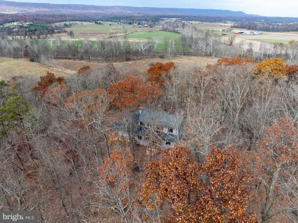 a view of a hallway with wooden floor and a bathroom