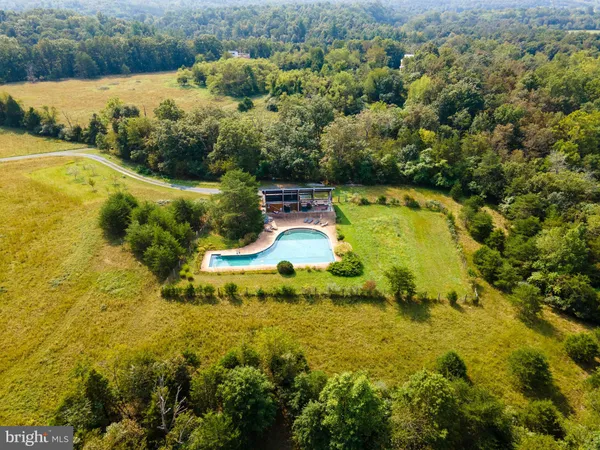 an aerial view of residential houses with outdoor space and lake view