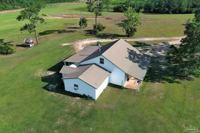 an aerial view of a house with a yard basket ball court and outdoor seating