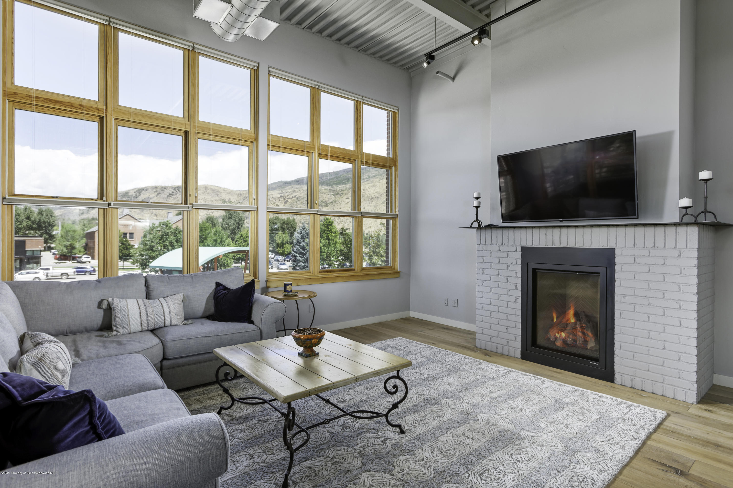 231 Robinson Street, Unit R212 Basalt, CO 81621 - Photo 2 of 14 a living room with furniture a flat screen tv and a fireplace