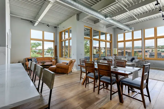 a dining room with furniture window and wooden floor