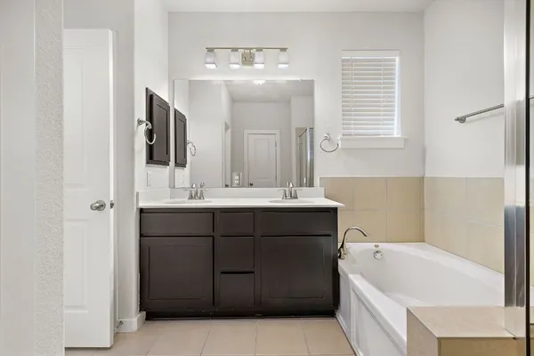 a bathroom with a tub sink and mirror