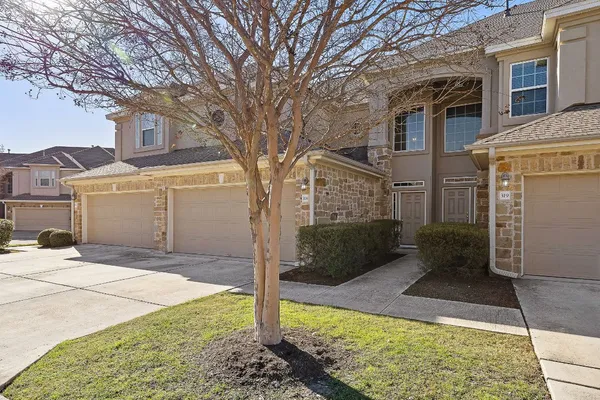 a view of a brick house with a large tree