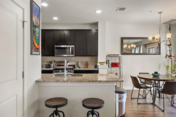 a kitchen with kitchen island granite countertop appliances cabinets and dining table