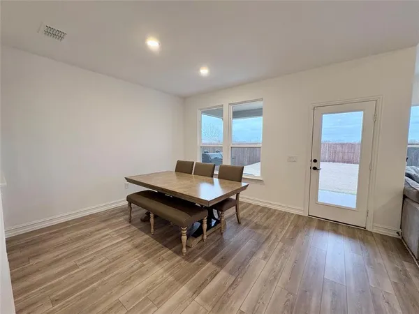 a room with furniture pool table wooden floor and windows