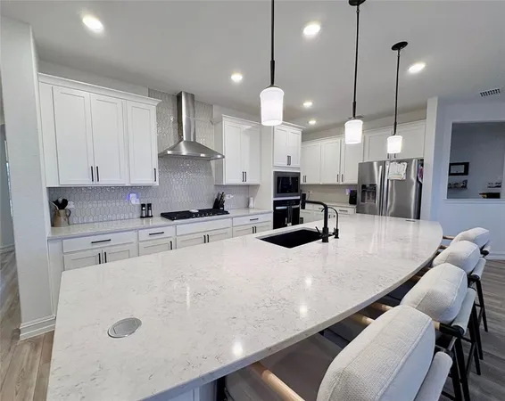 a large kitchen with kitchen island a counter space a sink appliances and cabinets