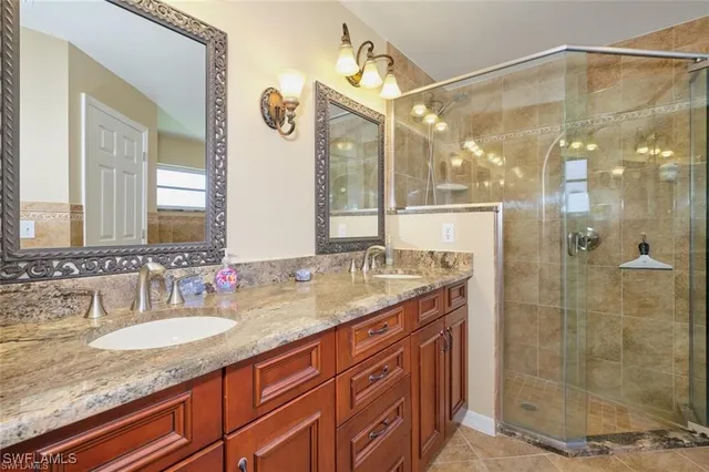 a bathroom with a granite countertop sink a mirror a glass door a shower and a mirror