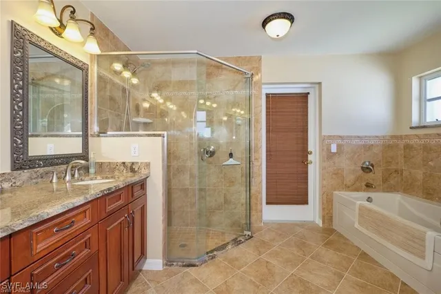 a bathroom with a granite countertop sink a mirror and a bathtub