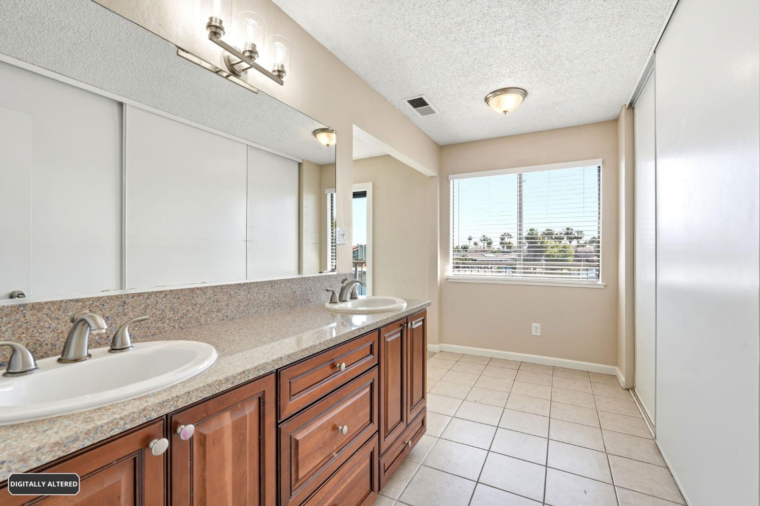5501 Riverlake Road Discovery Bay, CA 94505 - Photo 39 of 60 a bathroom with a granite countertop sink a mirror and a bathtub