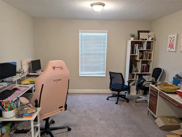 a view of a workspace with furniture and a window