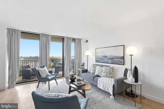 a living room with furniture and a floor to ceiling window