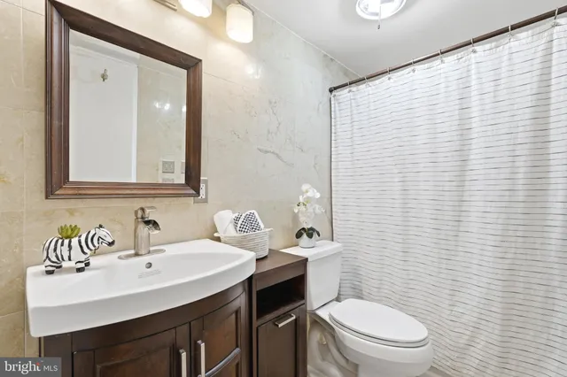 a bathroom with a toilet a sink a mirror and a shower