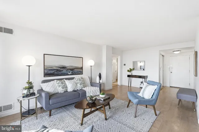 a living room with furniture and a painting on the wall