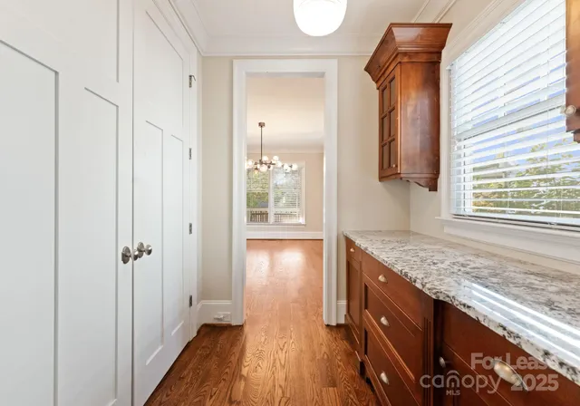 a view of hallway with wooden floor and cabinet