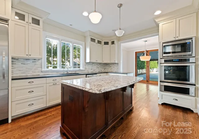 a kitchen with stainless steel appliances granite countertop a stove and cabinets