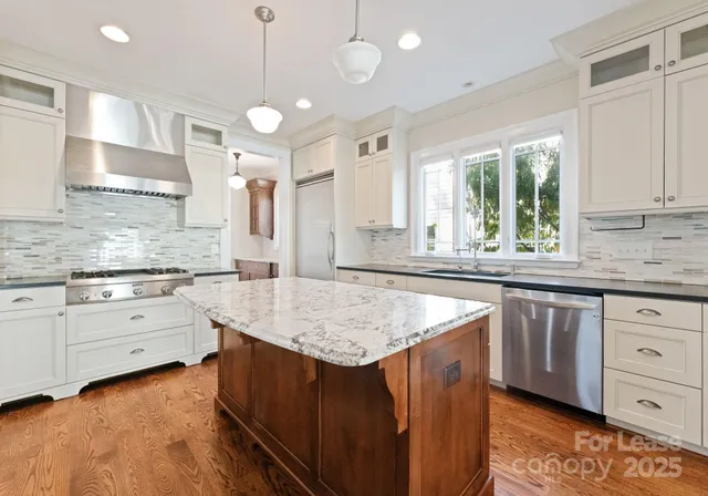 a kitchen with sink cabinets and chandelier