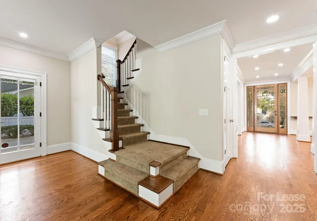 a view of a hallway with wooden floor and staircase