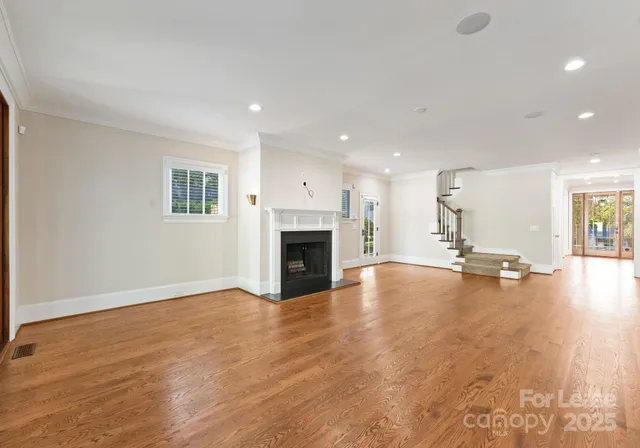 a view of empty room with wooden floor and fireplace