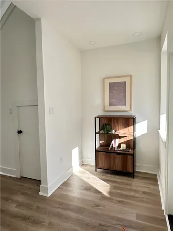 a view of a livingroom with wooden floor and a fireplace