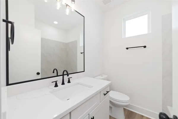 a bathroom with a sink a toilet and mirror