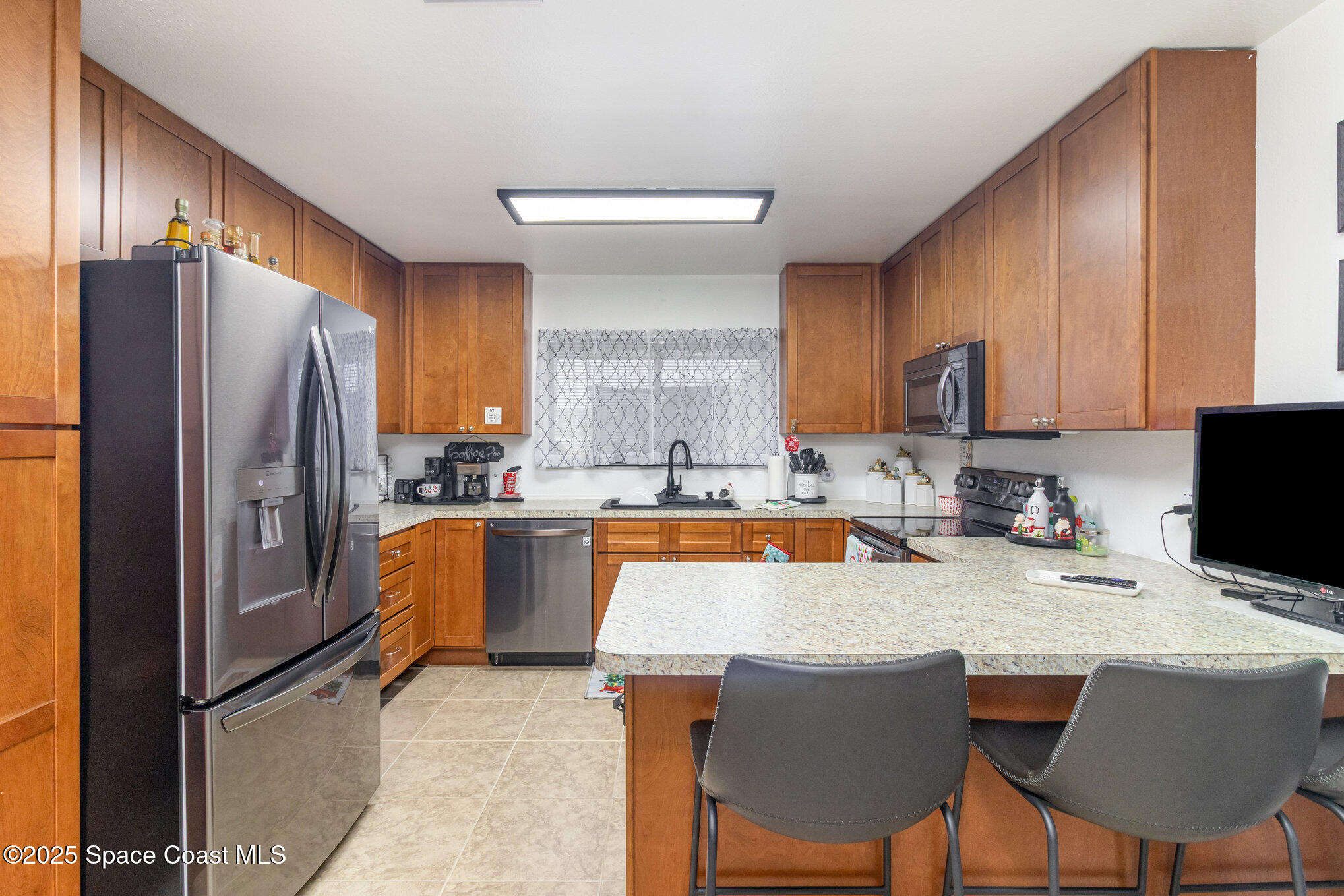1679 Dawes Road Northeast Palm Bay, FL 32905 - Photo 5 of 15 a kitchen with stainless steel appliances granite countertop a table chairs refrigerator a sink dishwasher and microwave oven