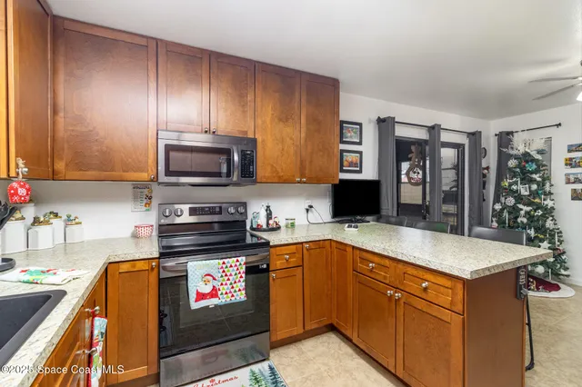 a kitchen with stainless steel appliances granite countertop a stove top oven a sink dishwasher and a microwave oven on the blue kitchen countertops
