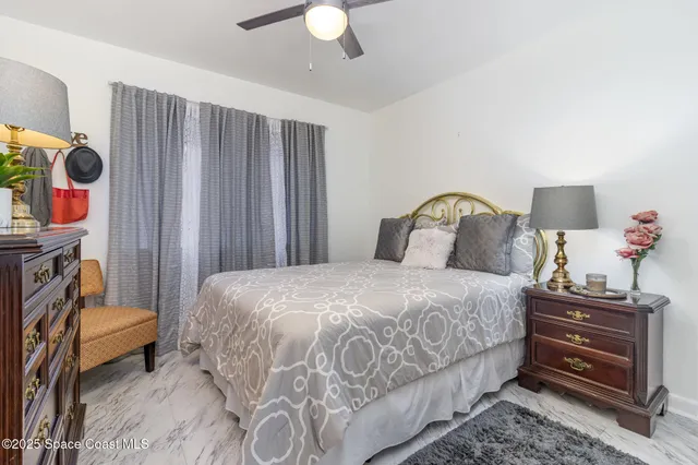 a bedroom with a bed and a potted plant on the dresser
