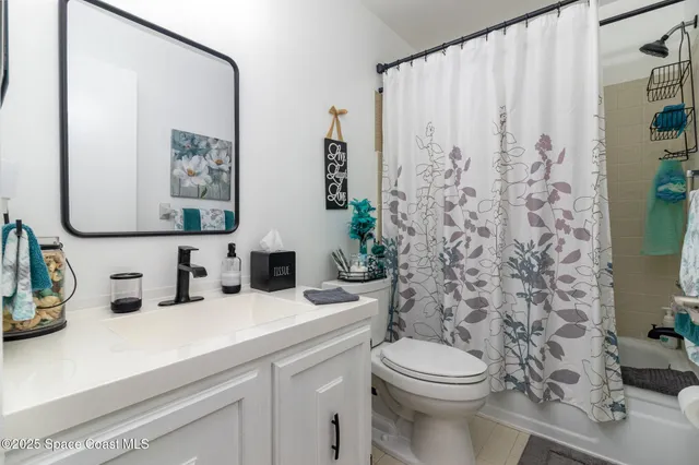 a bathroom with a sink a toilet and shower curtain