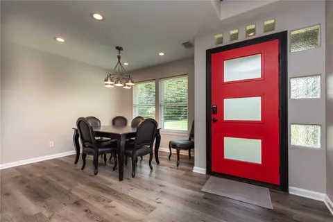 a view of a dining room with furniture a chandelier and wooden floor