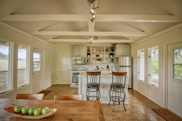 a kitchen with a table chairs stove and refrigerator