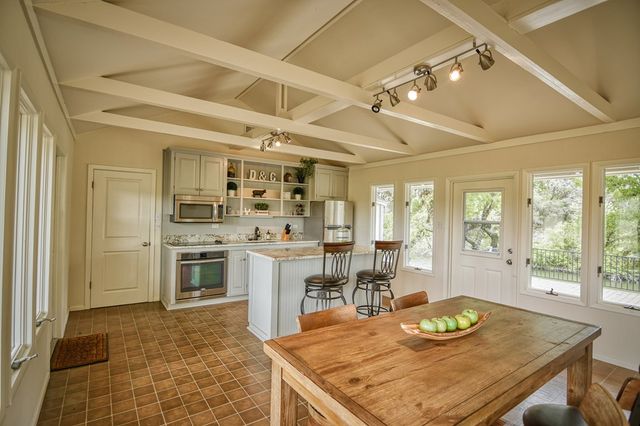 a living room with furniture large windows and flat screen tv