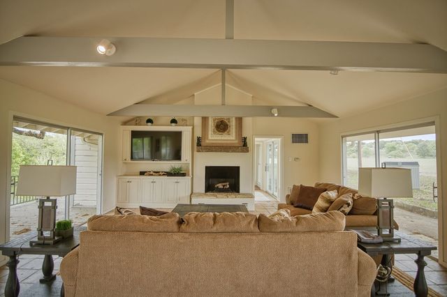 a living room with furniture a flat screen tv and a table
