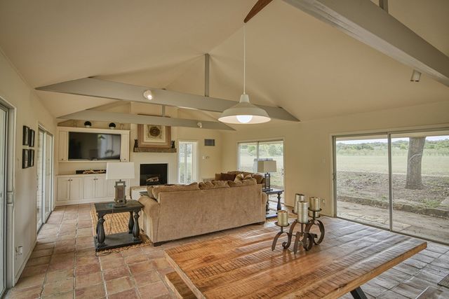 a living room with furniture a flat screen tv and kitchen view