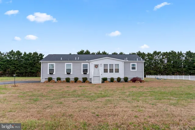 a front view of a house with a yard and palm trees