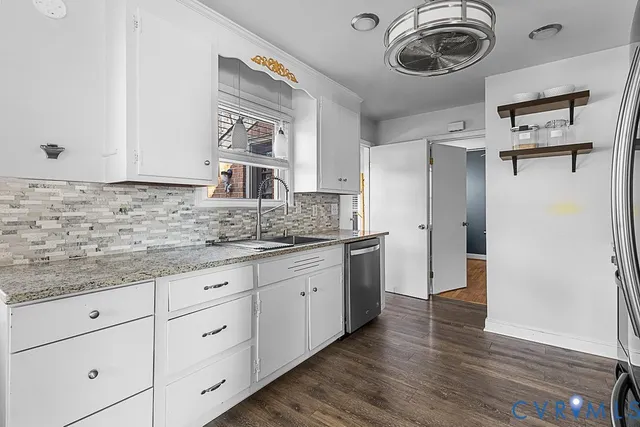 a kitchen with cabinets a sink and a wooden floor