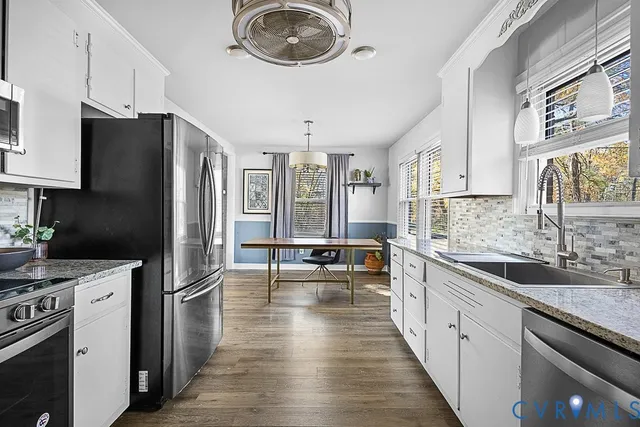 a kitchen with stainless steel appliances a stove a sink a refrigerator and cabinets