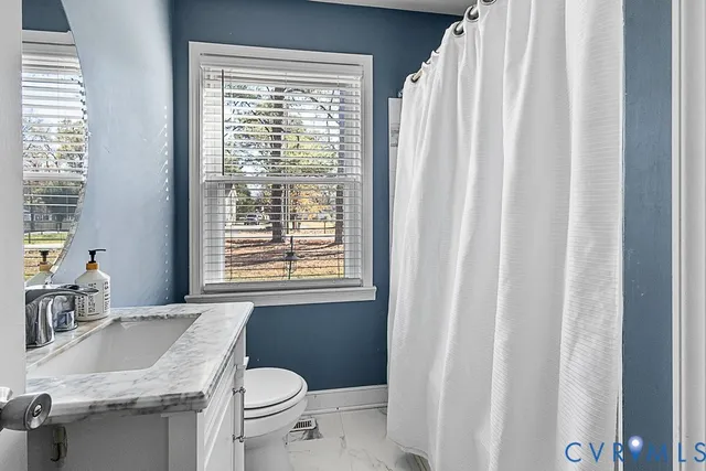 a bathroom with a granite countertop sink toilet and a mirror
