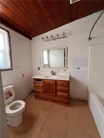 a spacious bathroom with a toilet sink and mirror