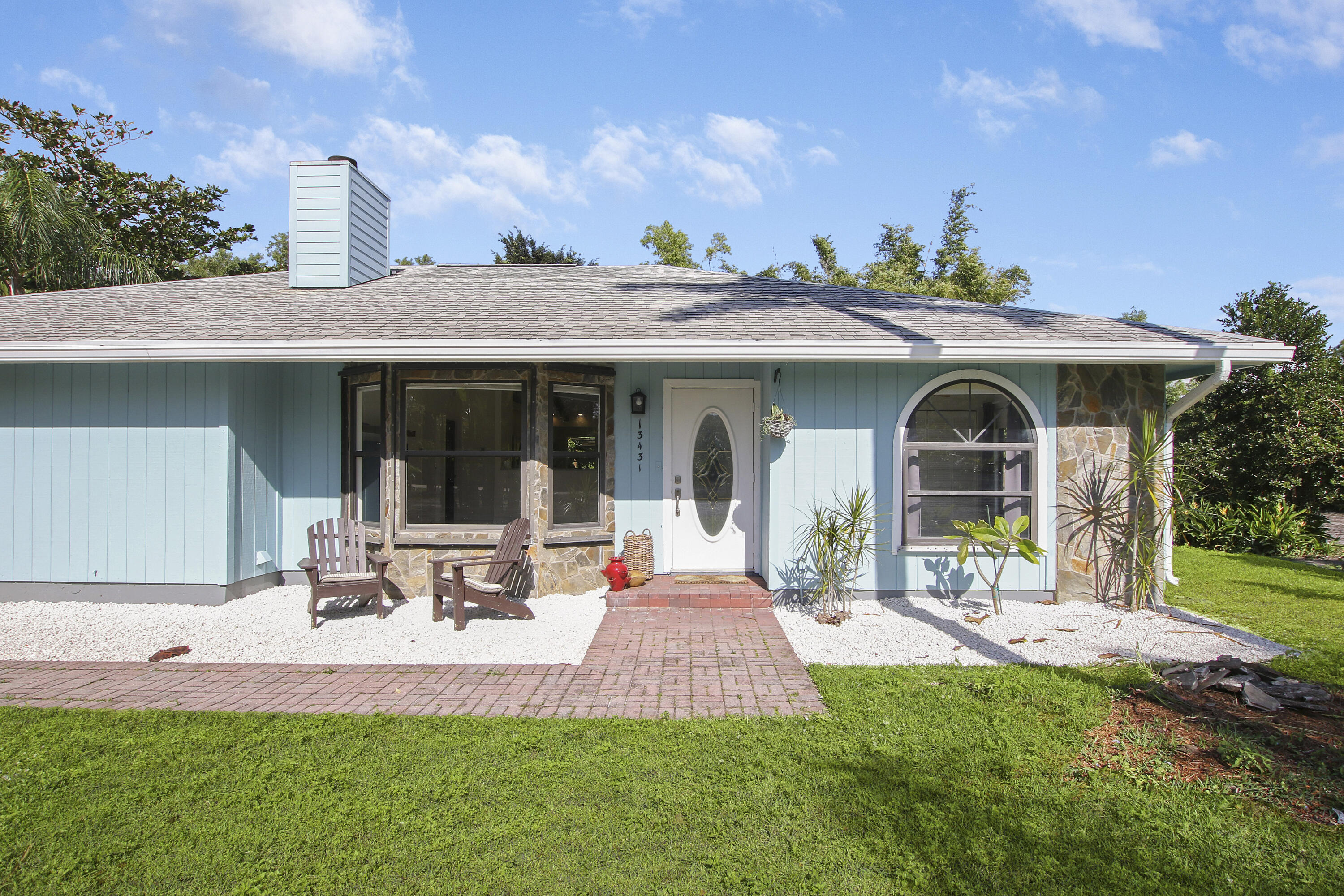 13431 153rd Road North Jupiter, FL 33478 - Photo 2 of 44 a front view of a house with garden and porch