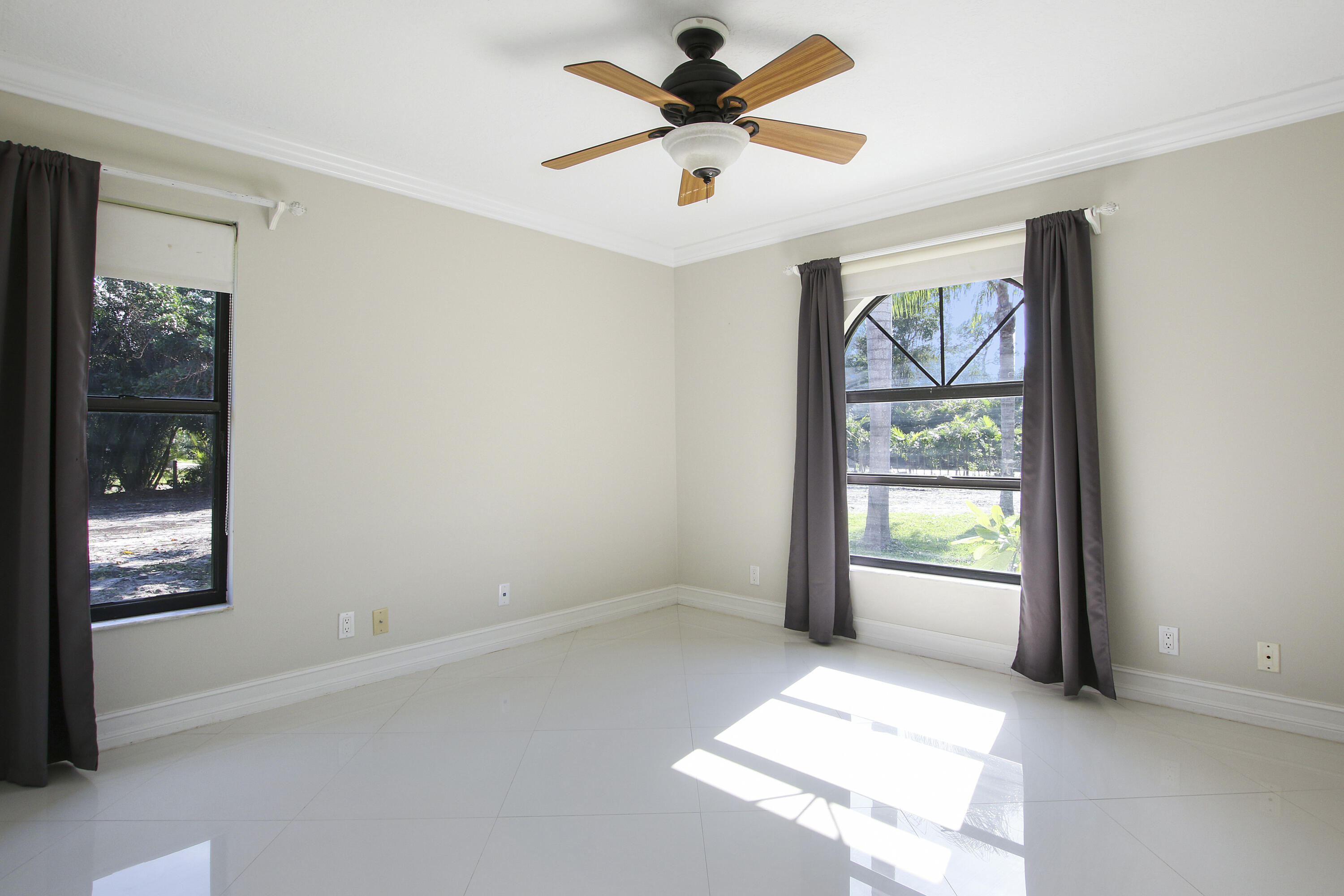 13431 153rd Road North Jupiter, FL 33478 - Photo 17 of 44 an empty room with windows and ceiling fan