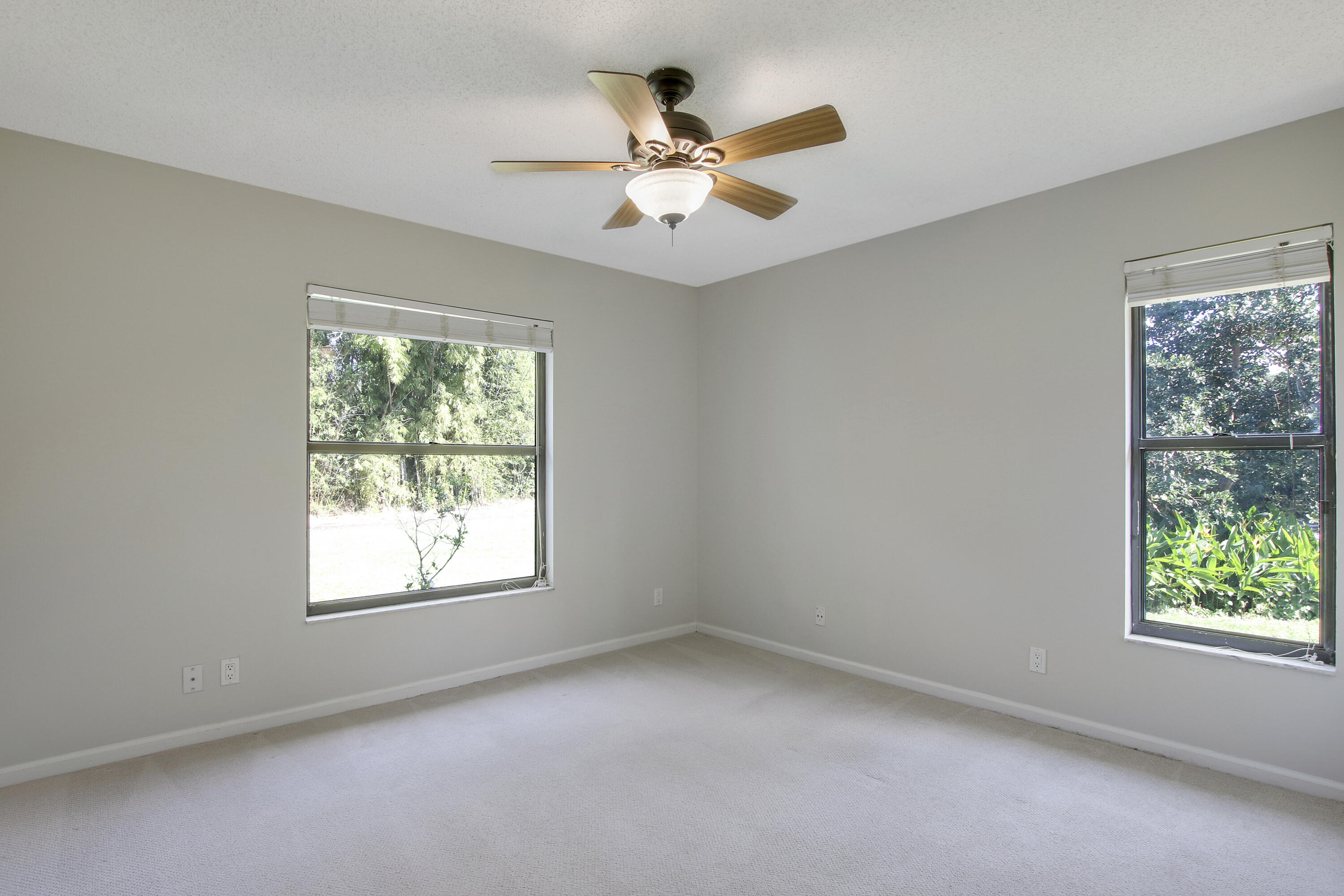 13431 153rd Road North Jupiter, FL 33478 - Photo 18 of 44 an empty room with a window and a fan